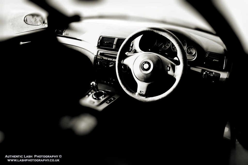 inside view of car steering wheel and gear stick - black and white image