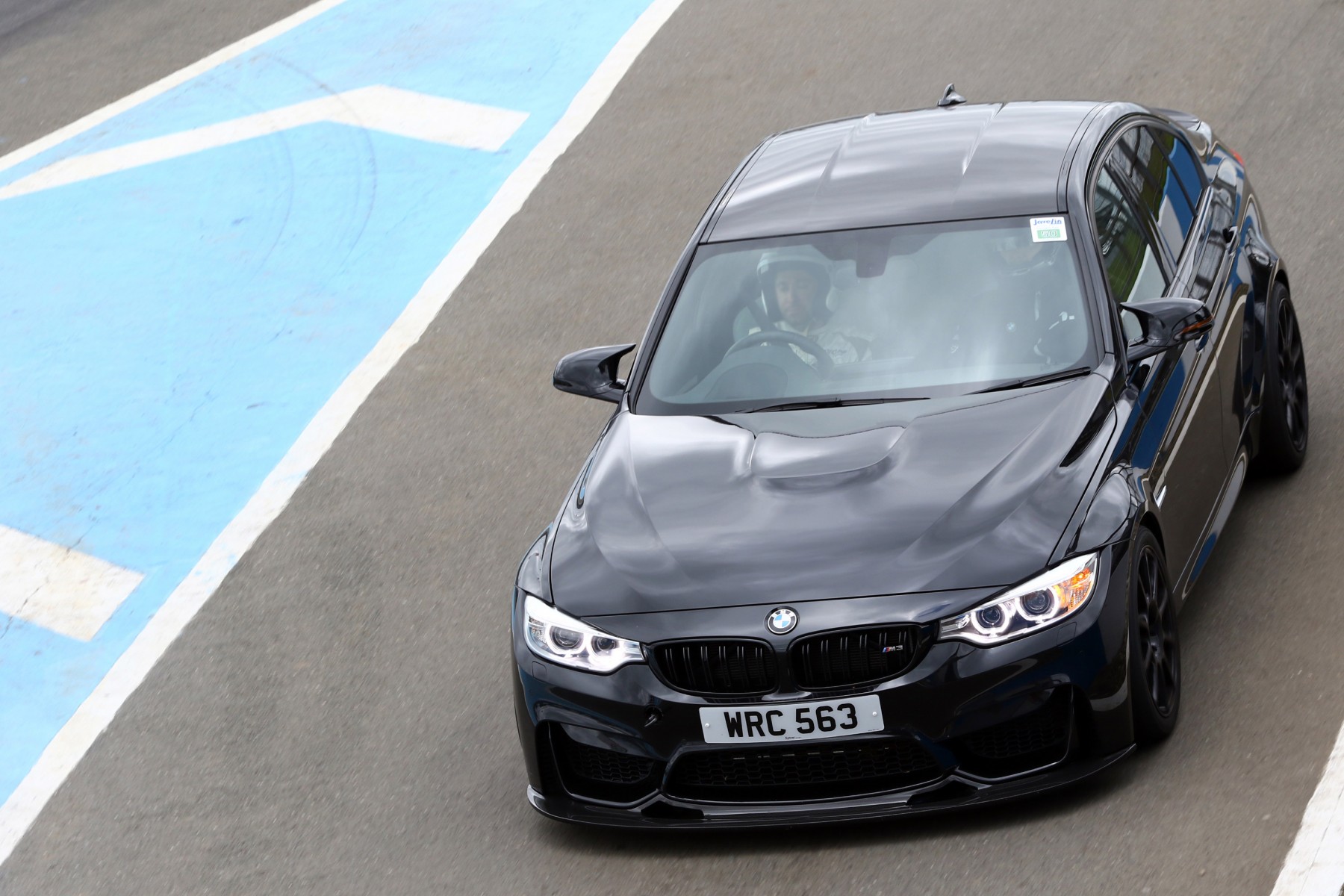 black bmw on track with racing driver