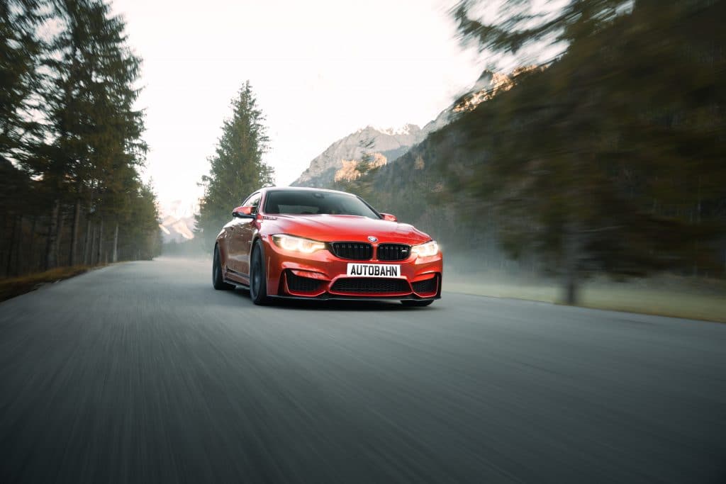 bmw modifications - red bmw driving at speed
